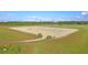 Wide angle showcasing a large equestrian arena with sandy surface and perimeter fencing set against a treeline at 4385 Ten Shillings Way, Hollywood, SC 29470