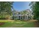 Charming two-story traditional home with a manicured lawn, a welcoming porch, and lush landscaping at 4385 Ten Shillings Way, Hollywood, SC 29470