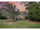 Elegant two-story home with a welcoming front porch, lush greenery, and mature trees enhancing curb appeal at 4385 Ten Shillings Way, Hollywood, SC 29470