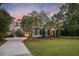Elegant two-story home with a welcoming front porch, lush greenery, and mature trees enhancing curb appeal at 4385 Ten Shillings Way, Hollywood, SC 29470