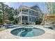 Charming two-story house with a spacious porch overlooking a beautifully landscaped backyard with a pool and spa at 4385 Ten Shillings Way, Hollywood, SC 29470