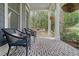 Inviting front porch featuring brick flooring, comfortable seating, and a charming porch swing at 4385 Ten Shillings Way, Hollywood, SC 29470