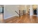 Hallway with wood floors and railing leading to laundry room at 4385 Ten Shillings Way, Hollywood, SC 29470
