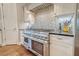 Gourmet kitchen with a professional-grade range, modern backsplash, and stainless steel appliances at 4385 Ten Shillings Way, Hollywood, SC 29470