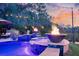 Outdoor area with pool, fire bowls, hot tub, umbrella, lounge chairs, and string lights at dusk at 4385 Ten Shillings Way, Hollywood, SC 29470