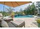 Inviting backyard pool with travertine tile, lounge chairs, ambient lighting, and lush landscaping, perfect for relaxation at 4385 Ten Shillings Way, Hollywood, SC 29470