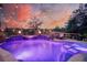 Inviting outdoor pool and spa illuminated with colorful lights, perfect for evening relaxation and entertainment at 4385 Ten Shillings Way, Hollywood, SC 29470