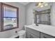 Well-lit bathroom features a gray vanity and a window overlooking the front yard at 522 W Butternut Rd, Summerville, SC 29483