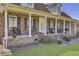 Inviting front porch with brick columns, rocking chairs, and well-manicured landscaping at 522 W Butternut Rd, Summerville, SC 29483