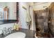 Stylish bathroom with a dark vanity, stone-tiled shower, and chrome fixtures at 53 America St, Charleston, SC 29403