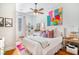 Bright bedroom featuring a large bed with colorful pillows, artwork, and a desk underneath window at 53 America St, Charleston, SC 29403