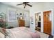 Bright bedroom with ensuite bathroom boasts a ceiling fan, dresser, and warm natural light at 53 America St, Charleston, SC 29403