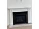 Close-up of a modern fireplace with a white mantel and black surround at 586 Marsh Cove Cir, Summerville, SC 29486