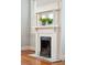 Ornate white fireplace mantel with dark metal firebox, tile surround, and hardwood floors at 6 Halsey St, Charleston, SC 29401