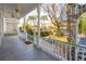 Inviting front porch with white railings, fan, and view of manicured landscaping and a spiral staircase to upper floor at 6 Halsey St, Charleston, SC 29401
