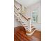 Elegant staircase with wood and white accents, and a stained glass window at 6 Halsey St, Charleston, SC 29401