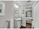 Well-lit bathroom with a pedestal sink, black tile flooring, and a doorway to the bedroom at 74 6Th Ave, Charleston, SC 29403