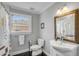 Charming bathroom with black tile floors, decorative mirror, and a window providing natural light at 74 6Th Ave, Charleston, SC 29403