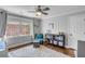 Cozy bedroom featuring hardwood floors, a ceiling fan, and a large window for natural light at 74 6Th Ave, Charleston, SC 29403