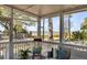 Charming covered porch view with comfortable seating and scenic street view of trees and partial view of the ocean at 74 6Th Ave, Charleston, SC 29403