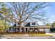Charming two-story home featuring a basketball hoop, picket fence, brick accents, and mature trees at 74 6Th Ave, Charleston, SC 29403