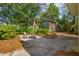 Charming backyard with mature trees, a shed, stone patio and ample seating at 840 Burger St, Charleston, SC 29407