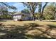 Spacious backyard with mature trees, and a pool in the background, perfect for outdoor enjoyment at 8834 Palmetto Rd, Edisto Island, SC 29438