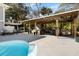 Inviting backyard with a covered outdoor kitchen, a sparkling pool, and comfortable seating areas at 8834 Palmetto Rd, Edisto Island, SC 29438