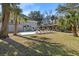 Expansive backyard featuring a pool, lounge chairs, and outdoor covered kitchen area, perfect for entertaining at 8834 Palmetto Rd, Edisto Island, SC 29438