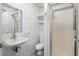 Bathroom featuring essential fixtures: sink, toilet, shelves, and a glass-doored shower at 8834 Palmetto Rd, Edisto Island, SC 29438