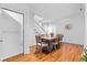 Dining area with hardwood floors, a large wooden table with seating for eight, and a view of the staircase at 8834 Palmetto Rd, Edisto Island, SC 29438