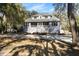 Inviting two-story home with a charming front porch and well-maintained landscaping and driveway at 8834 Palmetto Rd, Edisto Island, SC 29438