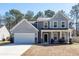 Charming two-story home featuring a welcoming front porch, attached garage, and beautiful architectural details at 9620 Corby Ct, Summerville, SC 29485