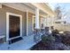 Inviting front porch features stone detailing, white columns and a cozy space for outdoor seating at 9620 Corby Ct, Summerville, SC 29485
