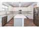 Modern kitchen features stainless steel appliances, white cabinets, and a large island with granite countertops at 9620 Corby Ct, Summerville, SC 29485
