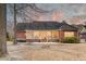 Backyard of brick home with covered porch, patio and expansive lawn under colorful sky at 1006 Retreat Ave, Moncks Corner, SC 29461