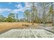 Landscaped backyard with a brick patio, fire pit and expansive yard that backs up to trees at 1006 Retreat Ave, Moncks Corner, SC 29461