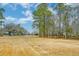 Spacious backyard featuring a lush grassy area and a line of trees that provides privacy and seclusion at 1006 Retreat Ave, Moncks Corner, SC 29461
