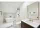 Bright bathroom featuring marble walls, a soaking tub, glass enclosed shower, and modern fixtures at 111 S Battery St, Charleston, SC 29401