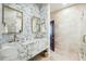 Elegant bathroom with marble walls and countertop, dual sinks, and gold fixtures at 111 S Battery St, Charleston, SC 29401