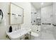 Bathroom with glass shower, marble walls, and modern sink with gold mirror at 111 S Battery St, Charleston, SC 29401