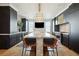 Bright kitchen featuring a large island with seating, dark cabinets, marble accents, and modern appliances at 111 S Battery St, Charleston, SC 29401