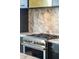 Close up of a stainless steel gas range with custom metal hardware and marble backsplash in a modern kitchen at 111 S Battery St, Charleston, SC 29401