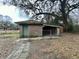 Exterior view of brick outbuilding, featuring a gated carport and moss covered roof at 113 Germantown Rd, Summerville, SC 29483