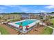 Community pool with ample seating, umbrellas, and palm trees under a clear sky at 123 Grange Cir, Summerville, SC 29486