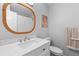 A modern bathroom with a marble countertop vanity, an oval mirror, and stylish decorative art at 1236 Lakefront Dr, Charleston, SC 29412