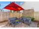 A relaxing backyard patio featuring comfortable seating and a vibrant red umbrella for shade at 1236 Lakefront Dr, Charleston, SC 29412