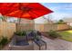 A cozy backyard patio with outdoor seating under a large red umbrella, perfect for relaxing at 1236 Lakefront Dr, Charleston, SC 29412