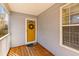 Inviting front porch showcasing a vibrant yellow front door, a welcoming wreath and wood flooring at 1236 Lakefront Dr, Charleston, SC 29412
