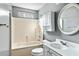 Bright bathroom with vanity, tub/shower combo, storage and an oval mirror at 129 E Hartwick Ln, Goose Creek, SC 29445